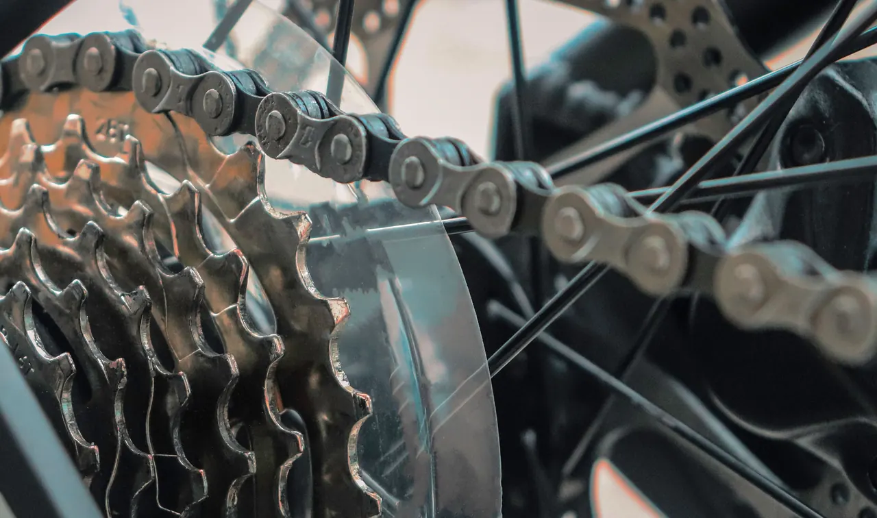 Close-up of a bicycle drivetrain: rear cassette, chain, spokes and disc brake rotor