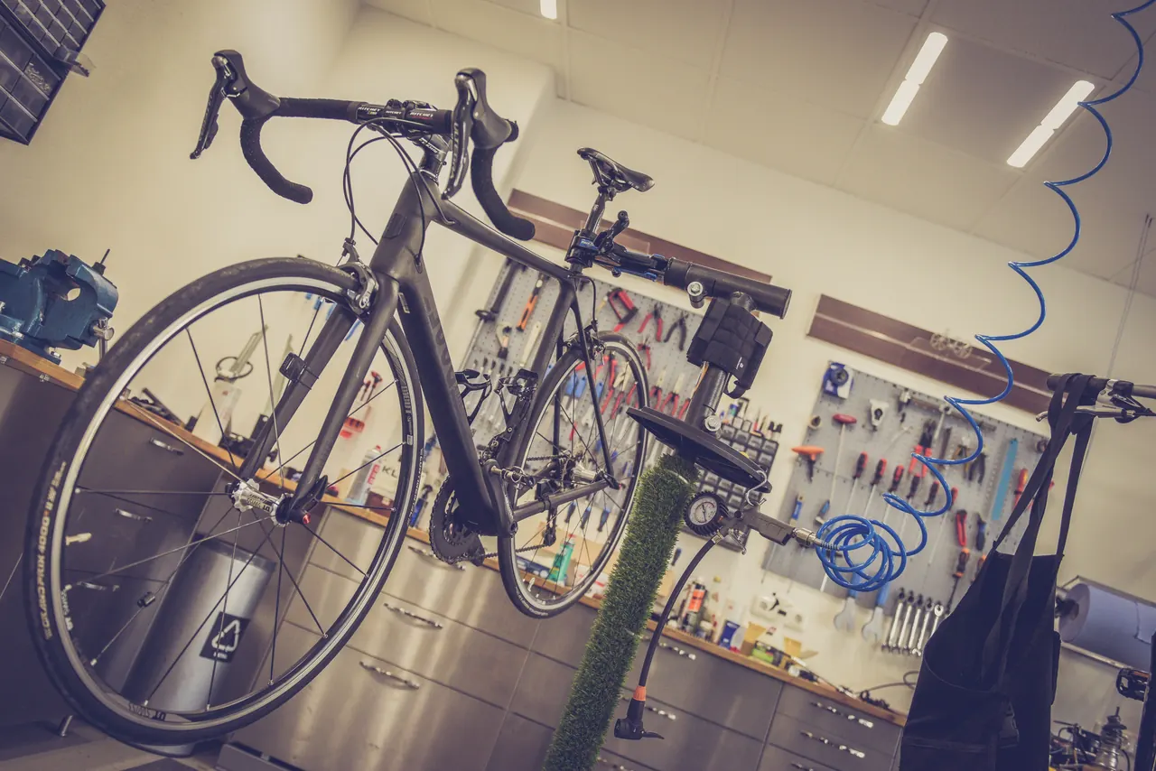 Road bike held in a workstand in a bicycle repair workshop