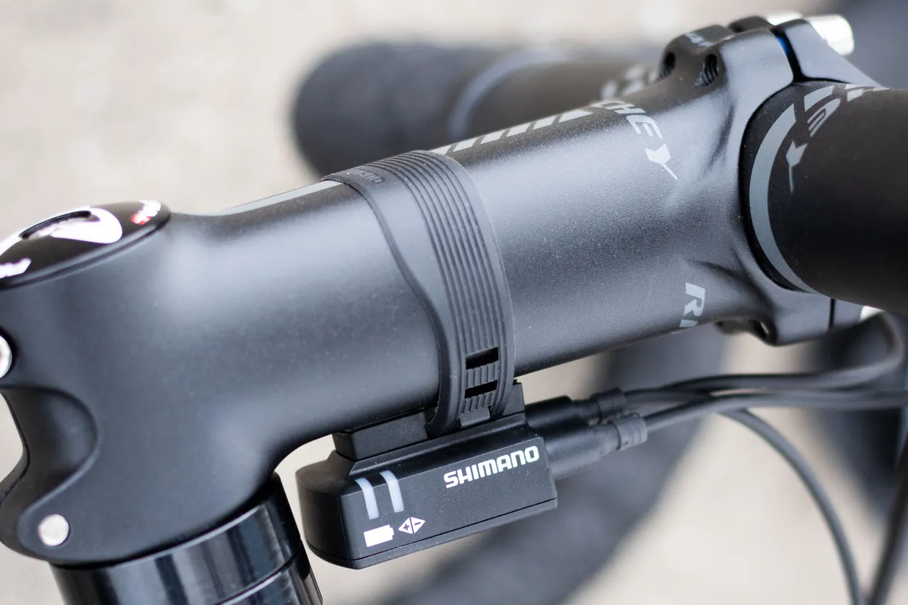 Black handlebar stem clamping the handlebar, seen close up from the side